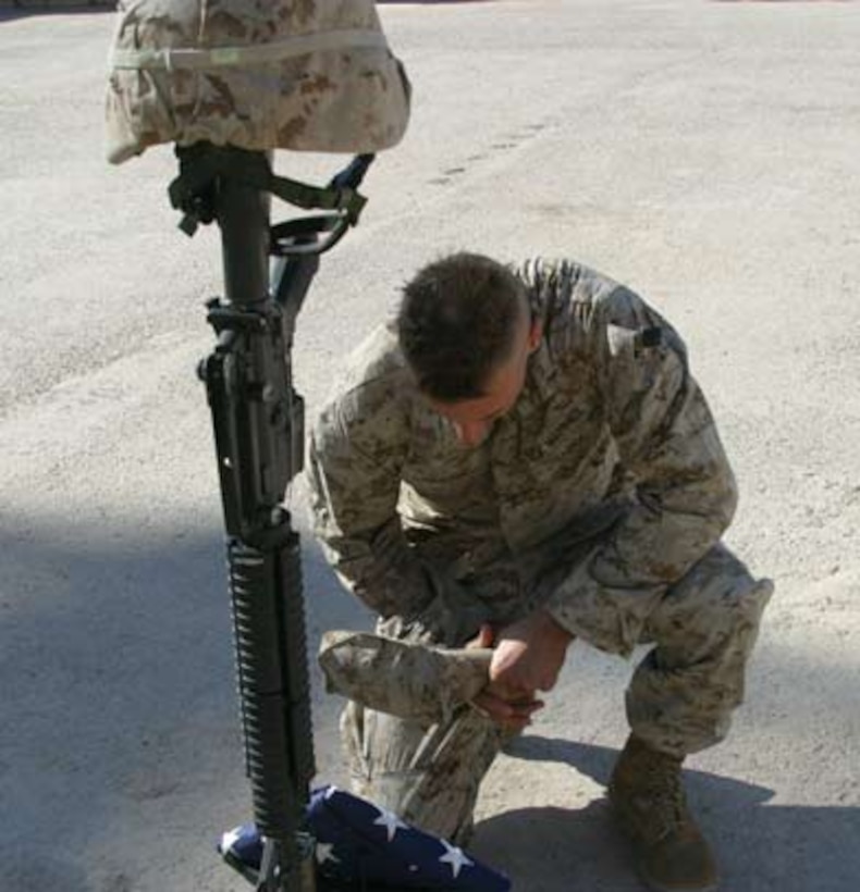 Second Lt. Mario S. Parzino pays his respects to Cpl. Joshua D. Snyder during a memorial service Dec. 11.  Snyder, a 20-year-old Hampstead, Md. Native, was killed in action Nov. 30, 2005 by anti-coalition forces while deployed with Company E, 2nd Battalion, 6th Marines.