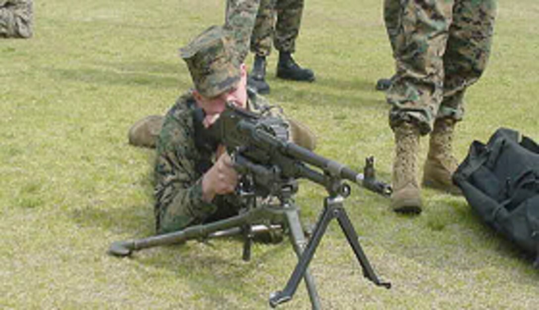A Marine Aviation Logistics Squadron 12 Marine looks down the site of a M240G during a weapons familiarization and tactical emplacement class, recently.