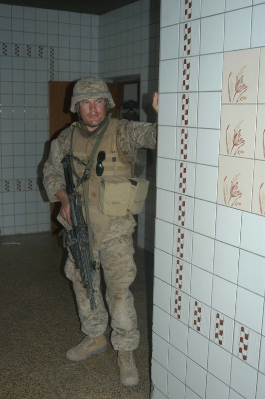 AR RAMADI, Iraq (April 11, 2005) - Corporal David B. Northridge, a 25-year-old squad automatic gunner with 2nd Squad, 1st Platoon, Company A, 1st Battalion, 5th Marine Regiment, posts security from inside a building during a patrol through the city here with his fellow squad members. The 25-year-old Billings, Mont., native and his fellow leathernecks with 2nd Squad, 1st Platoon, Company A, 1st Battalion, 5th Marines, have become familiar with their area of operations where they conduct security and stability operations almost daily. They've learned to recognize landmarks to help determine what particular street they're patrolling. First Battalion, 5th Marines are two months into their seven-month deployment here in support of Operation Iraqi Freedom. Photo by Cpl. Tom Sloan