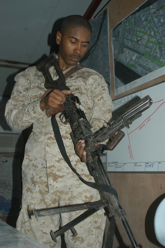 CAMP HURRICANE POINT Ar Ramadi, Iraq (May 12, 2005) - Corporal Christopher B. Randall, a scout with 1st Platoon, Company W, 1st Battalion, 5th Marine Regiment, performs a function check on PKM machine gun he his fellow warriors took from insurgents during a mission in the city. The 20-year-old from St. Loius and other Marines with 1st Platoon killed three insurgents while responding to a casualty evacuation request. The Marines discovered a rocket propelled grenade launcher, a PKM machine gun with more than 100 armor-piercing rounds, a Romanian assault rife, three AK-47 assault rifles and more than 300 rounds of ammunition. Photo by Cpl. Tom Sloan