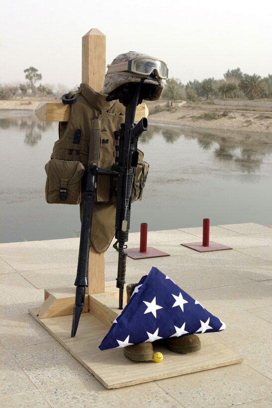CAMP BAHARIA, Iraq - Lance Cpl. Mario A. Castillo's gear display rests near the water's edge here June 12 before the memorial service.  The 20-year-old Brownwood, Texas served as a combat engineer with 2nd Platoon, Company A, 2nd Combat Engineer Battalion, currently supporting 1st Battalion, 6th Marine Regiment counter-insurgency operations in Fallujah, and passed away June 10 when an improvised explosive device detonated near his vehicle.