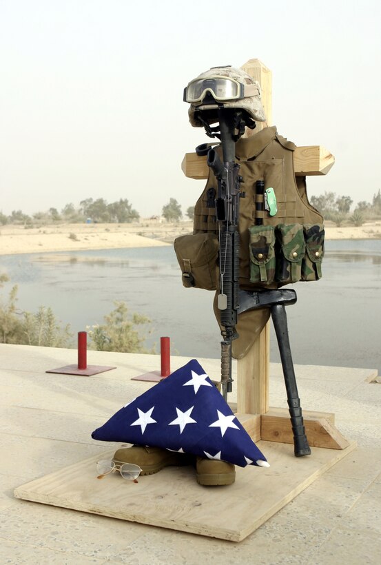 CAMP BAHARIA, Iraq - Lance Cpl. Andrew J. Kilpela's gear display rests near the water's edge here June 12 before the memorial service.  The 22-year-old Livingston, Mich. served as a combat engineer with 2nd Platoon, Company A, 2nd Combat Engineer Battalion, currently supporting 1st Battalion, 6th Marine Regiment counter-insurgency operations in Fallujah, and passed away June 10 when an improvised explosive device detonated near his vehicle.