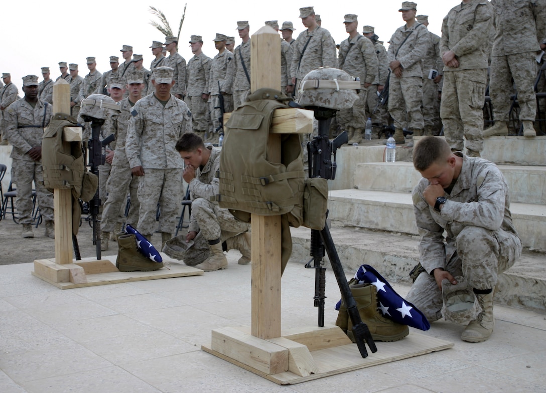 CAMP BAHARIA, Iraq - Marines with 2nd Platoon, Company A, 2nd Combat Engineer Battalion, pay their final respects to Lance Cpl. Mario Castillo and Lance Cpl. Andrew Kilpela during a memorial service here June 12.  The two engineers passed away June 10 when an improvised explosive device detonated near their vehicle in a roadway outside Fallujah.