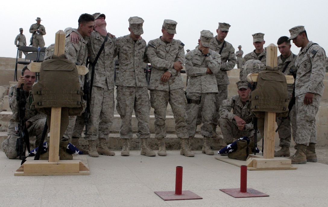 CAMP BAHARIA, Iraq - Combat engineers from 2nd Platoon, Company A, 2nd Combat Engineer Battalion comfort each other as they pay their final respects to fallen brothers, Lance Cpl. Mario Castillo and Lance Cpl. Andrew Kilpela, after a memorial service here June 12.  The two engineers passed away June 10 when an improvised explosive device detonated near their vehicle in a roadway outside Fallujah.