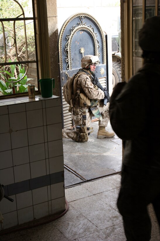 050912-M-8489S-004 AR RAMADI, Iraq (September 12, 2005) - A Marine with Company A, 1st Battalion, 5th Marine Regiment stands guard outside a house while the rest of his squad searches for weapons and enemies. This raid was one of many operations 1/5 did to help incoming 3rd Battalion, 7th Marine Regiment get used to the area. Photo by Cpl. Shane Suzuki