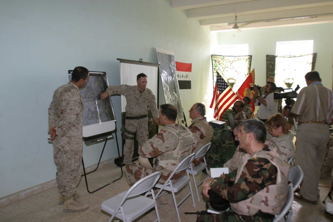 HADITHA, Iraq ? Lieutenant Col. Jeffrey R. Chessani, a Meeker Colo. native and commanding officer of 3rd Battalion, 1st Marine Regiment, briefs Lt. Gen. Abdul Qader, commander of all Iraqi infantry forces and others leaders Oct. 12 on recent joint operations. The Iraqi commander visited the area to meet with troops and discuss needs of the Iraqi forces to continue their mission here.