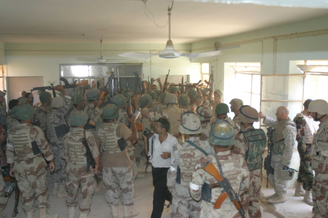 HADITHA, Iraq ? Iraqi troops welcome their commander, Lt. Gen. Abdul Qader, commander of all Iraqi infantry forces, to Haditha with a traditional dance here Oct. 12. The Iraqi commander visited the area to meet with these troops and discuss needs of the Iraqi forces to continue their mission here.
