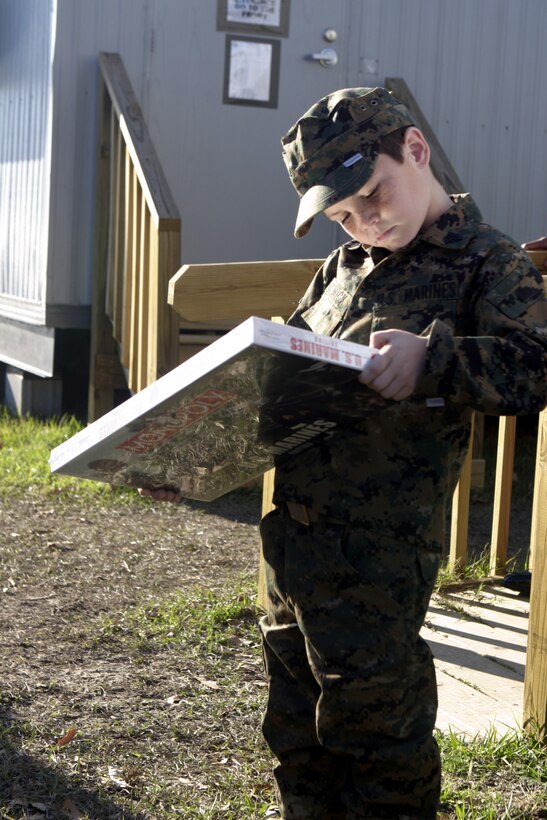 MARINE CORPS BASE CAMP LEJEUNE, N.C. - Six-year-old Brandon Rasnick stares at a Marine-themed board game given to him by Lt. Col. Bradley Vickers, 1st Battalion, 9th Marine Regiment's commander, outside the battalion's office here Dec. 12.  Brandon and his family visited numerous training grounds and units throughout the base while on a trip sponsored by the Make-a-Wish foundation to grant his wish of training alongside United States Marines.  Brandon is a boy from Lehigh Acres, Fla. who has cystic fibrosis, a genetic lung disorder.