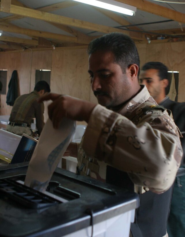 HADITHA DAM, Iraq (Dec. 12, 2005) - An Iraqi soldier casts the first ballot here during early Iraqi elections Dec. 12. The soldiers got a chance to vote before the actual Iraqi elections on Dec. 15 because they will be providing security all around the country at voting sites. (Official Marine Corps photo by Cpl. Adam C. Schnell)