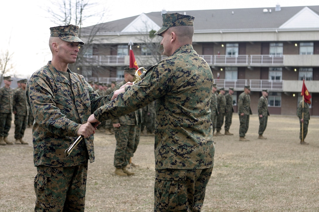 MARINE CORPS BASE CAMP LEJEUNE, N.C. - Sergeant Major T.F. Hall hands the noncommissioned officer's sword from Lt. Col. William Jurney, 1st Battalion, 6th Marine Regiment's commander, here Dec. 14 to officially resign the position of battalion sergeant major.  Hall, a veteran of Operations Enduring Freedom and Iraqi Freedom, was relieved by 1st Sgt. Ernest Hoopii.  Hall is currently 2nd Assault Amphibian Battalion's sergeant major.