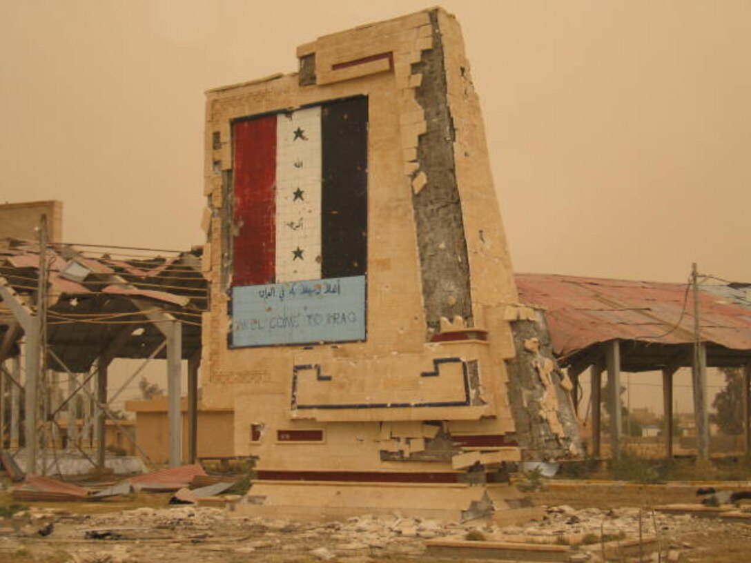 HUSAYBAH, Iraq - A sign welcoming those crossing the Syrian border to Iraq near Camp Gannon stands as a testiment of the Marines determination against the insurgents who attacked their camp with suicide vehicle-borne improvised explosive devices, small arms fire and RPGs April 11. Heavy small arms fire from insurgents destroyed the signs once pristine apperance.