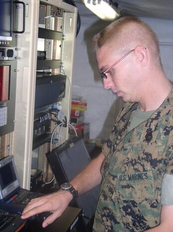 Gunnery Sgt. Matthew M. Smith, assistant combat camera project officer for Marine Corps Systems Command stand at one of the TIPS imagery workstation.  Imagery and Video workstations have one terabyte of backup storage.