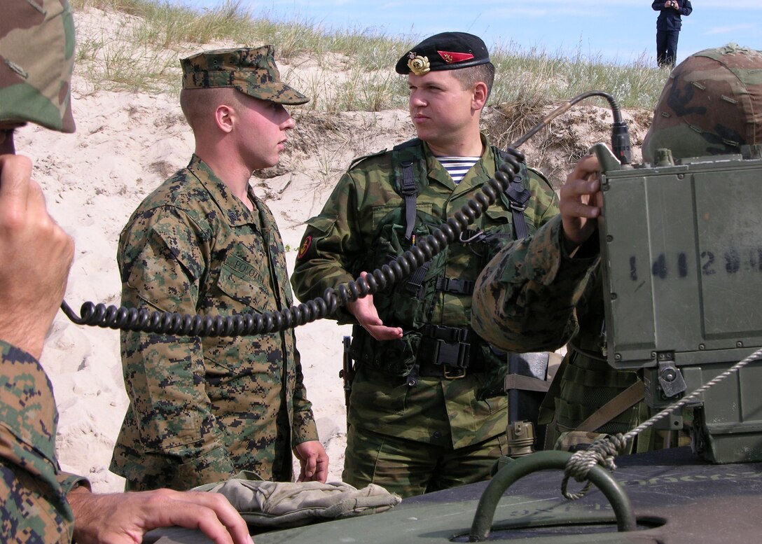USTKA TRAINING RANGE, Poland  -- Corporal Dmitry Polosov translates for a Russian officer during a noncombatant evacuation operation during exercise Baltic Operations 2005.  Polosov as well as Marines from 2nd Battalion 23rd Marines recently participated in the annual exercise involving more than 500 troops from 11 countries to improve interoperability between allies and Partnership for Peace nations.