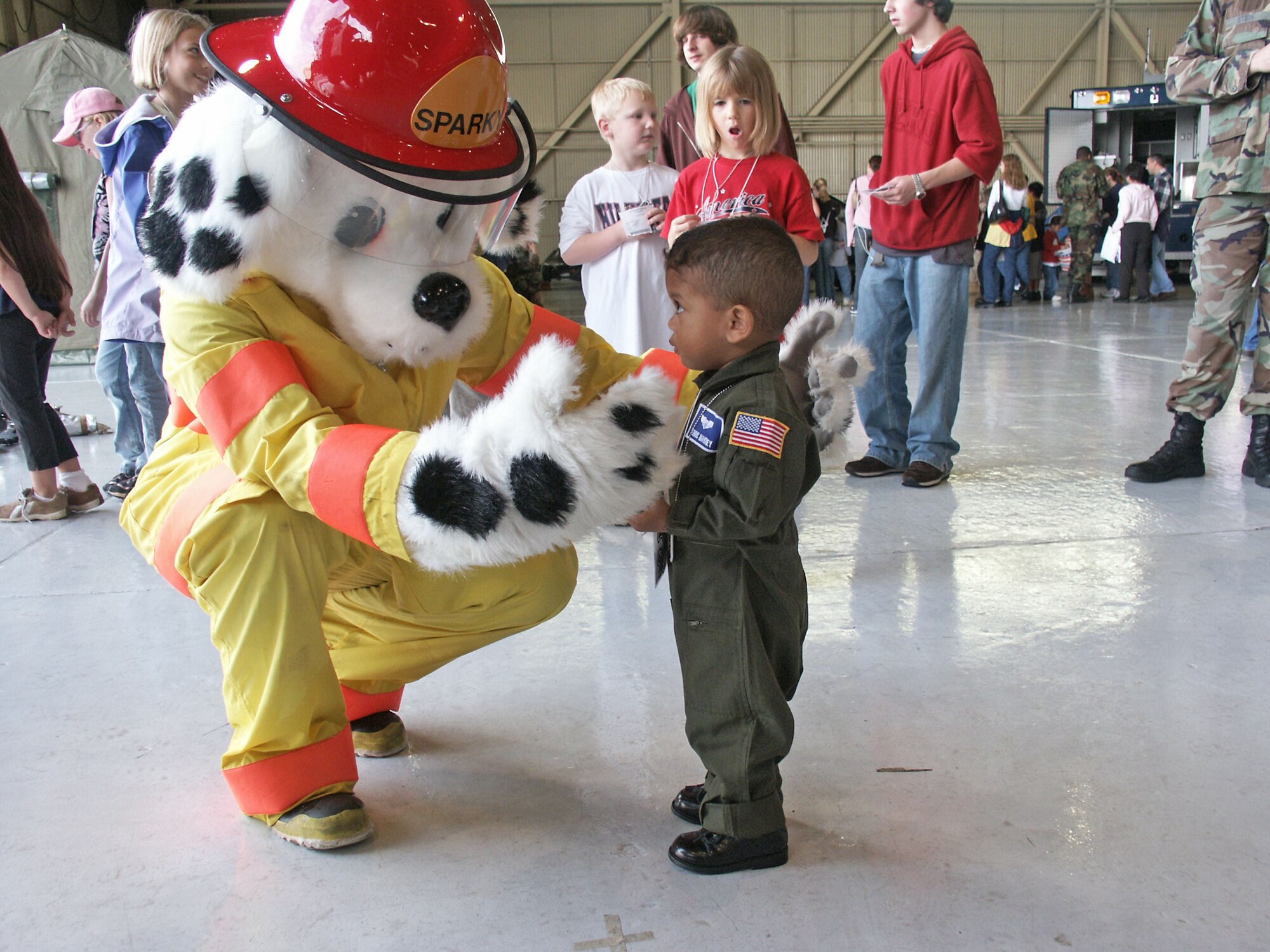 EGLIN AIR FORCE BASE, Fla. -- Dominic Mahoney warms up to Sparky the Fire Dog during Operation Hero held here Jan. 8.  The event was designed to help children better understand what a deployment is and what happens when their parents deploy.  The fire department helped children with remembering who and how to call for help in case of an emergency.  Dominic, 2, is the son of Senior Master Sgt. Kevin Mahoney of the 33rd Maintenance Squadron.  (U.S. Air Force photo by Staff Sgt. Robert Zoellner)