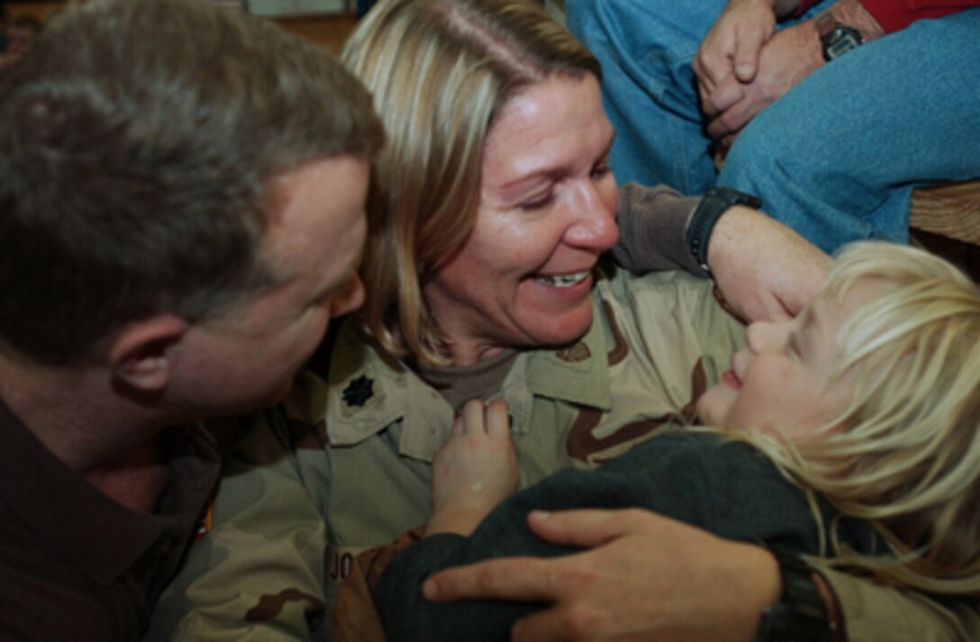Lt. Col. Marybell Johnson (center) shares a happy moment with her daughter and husband at Green Ramp, Fort Bragg, N.C., on Dec. 29, 2004, before deploying to Iraq for a year. Johnson is the commander of the 217th Personnel Support Branch of the North Carolina Army National Guard. 