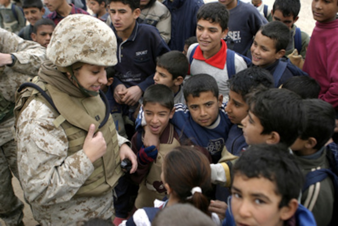 Navy Lt. Rasha Hanna (left) interacts with children during a Civil Affairs mission to the Girls Primary School in Abu Tiban, Iraq, on Jan. 5, 2005. Hanna is assigned as a Dental Officer to the 31st Marine Expeditionary Unit, Forward Deployed Preventative Medicine Unit, 4th Civil Affairs Group. 