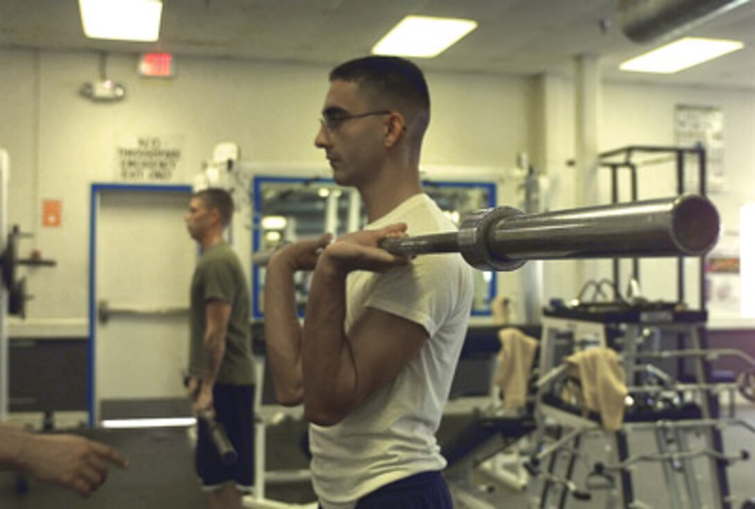 Cpl. Jose Santos, artillery mechanic, Fleet Support Division, receives instruction on the correct way to position the weight to avoid injury.