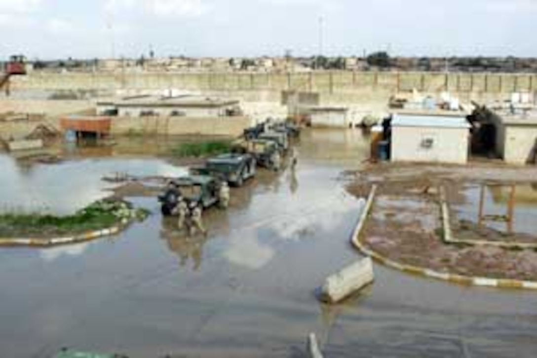Walking in more than six inches of water, Marines and soldiers begin another day of work at the Forward Operating Base here after it was hit by series of severe rain storms.  The 15th MEU is currently conducting security and stability operations in the greater Baghdad area.