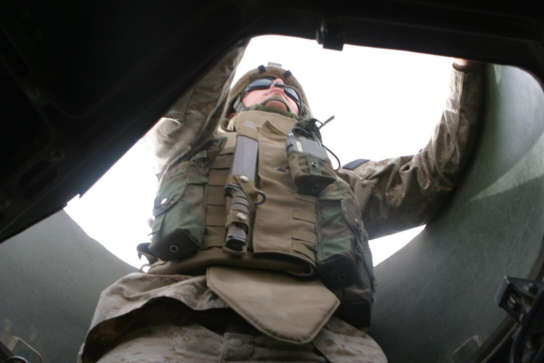 CAMP FALLUJAH, IRAQ -- Lance Cpl. Michael A. Romano, a motor transportation operator and machine gunner for combat train stands in his turret watching the rear of the convoy scanning the area for any possible threat of attack.  He takes everyday as if it were his first as he ensures Marines are taken where they are needed, supplies are delivered and all logistic needs are taken care of.  Official U.S. Marine Corps Photo by Lance Cpl. Athanasios L. Genos.