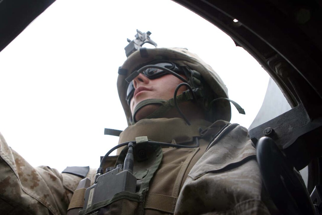 CAMP FALLUJAH, IRAQ -- Lance Cpl. Michael A. Romano, a motor transportation operator and machine gunner for combat train stands in his turret watching the rear of the convoy scanning the area for any possible threat of attack.  He takes everyday as if it were his first as he ensures Marines are taken where they are needed, supplies are delivered and all logistic needs are taken care of.  Official U.S. Marine Corps Photo by Lance Cpl. Athanasios L. Genos.