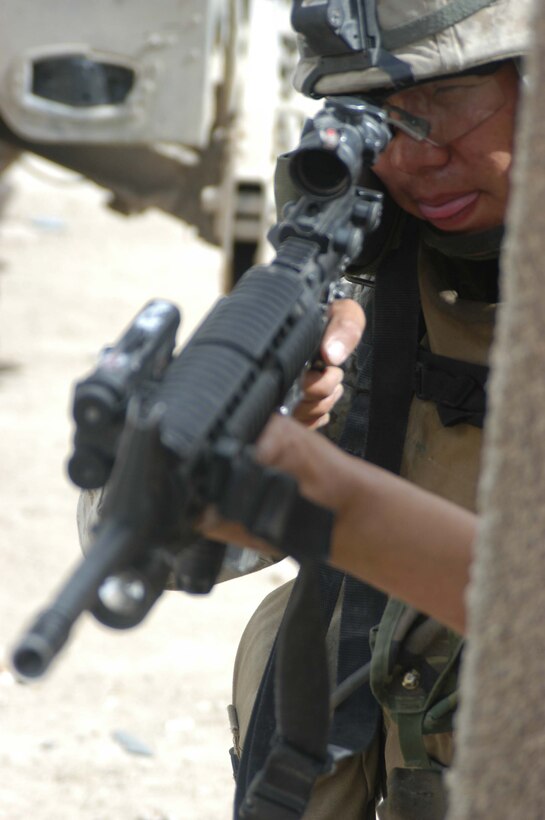 AR RAMADI, Iraq (April 13, 2005) - Lance Cpl. Chen Chen, a rifleman with 2nd Squad, 2nd Platoon, Company A, 1st Battalion, 5th Marine Regiment, aims his weapon down a street here and posts security for his fellow squad members as the cross from one side to the other. The 19-year-old Los Angeles native originally from Beijing, and other Marines with 2nd Platoon, Company A, 1st Battalion, 5th Marines, conducted a combat patrol through the southern portion of the city where insurgents have actively been engaging coalition forces. Insurgents engaged the leathernecks in drive-by shooting midway through their combat patrol. Photo by Cpl. Tom Sloan