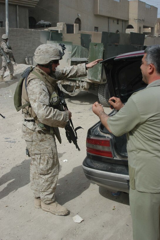 AR RAMADI, Iraq (April 13, 2005) - Corporal Adam C. Hartlove, a team leader with 2nd Squad, 2nd Platoon, Company A, 1st Battalion, 5th Marine Regiment, checks the contents of an Iraqi man's vehicle during a patrol through a portion of the city here. The 22-year-old Pasadena, Md., native and other Marines with 2nd Platoon, Company A, 1st Battalion, 5th Marines, conducted a combat patrol through the southern portion of the city where insurgents have actively been engaging coalition forces. Insurgents engaged the leathernecks in drive-by shooting midway through their combat patrol. Photo by Cpl. Tom Sloan