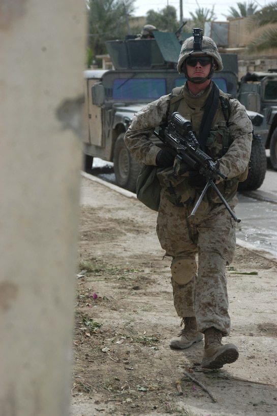 AR RAMADI, Iraq (April 13, 2005) -Lance Cpl. Chad B. Maynard, a squad automatic gunner with 2nd Squad, 2nd Platoon, Company A, 1st Battalion, 5th Marine Regiment, rounds a street corner while patrolling the streets here with his fellow Marines. The 19-year-old from Montrose, Colo., and other Marines with 2nd Platoon, Company A, 1st Battalion, 5th Marines, conducted a combat patrol through the southern portion of the city where insurgents have actively been engaging coalition forces. Insurgents engaged the leathernecks in drive-by shooting midway through their combat patrol. Photo by Cpl. Tom Sloan