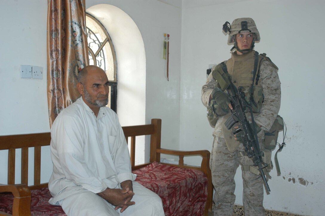 AR RAMADI, Iraq (April 13, 2005) - Corporal Michael S. Goeringer, an assault man with 2nd Squad, 2nd Platoon, Company A, 1st Battalion, 5th Marine Regiment, stands next to an Iraqi man whose home he and his fellow Marines are using for an over watch. The 21-year-ol Rapid City, S.D., native and other Marines with 2nd Platoon, Company A, 1st Battalion, 5th Marines, conducted a combat patrol through the southern portion of the city where insurgents have actively been engaging coalition forces. Insurgents engaged the leathernecks in drive-by shooting midway through their combat patrol. Photo by Cpl. Tom Sloan