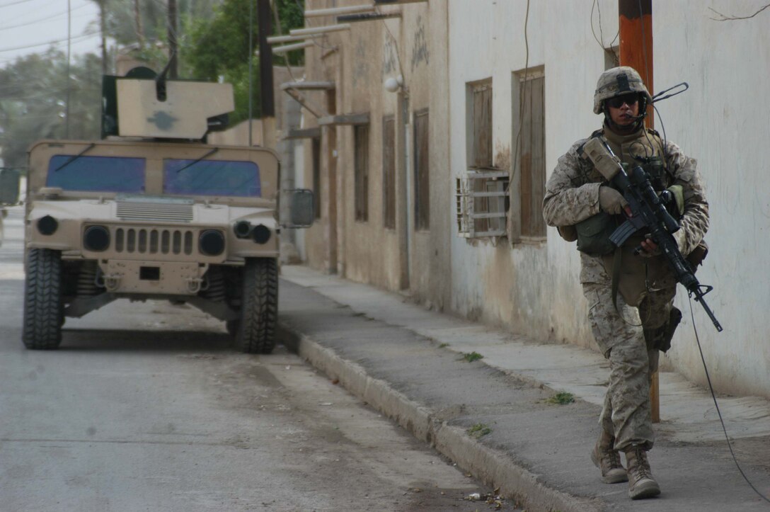 AR RAMADI, Iraq (April 13, 2005) -Sergeant Fidel A. Alcoces, platoon sergeant, Second Platoon, Company A, 1st Battalion, 5th Marine Regiment, walks down a street here during a patrol with his platoon. The 29-year-old San Antonio, Texas native and his platoon conducted a combat patrol through the southern portion of the city where insurgents have actively been engaging coalition forces. Insurgents engaged the leathernecks in drive-by shooting midway through their combat patrol. Photo by Cpl. Tom Sloan