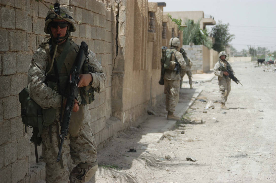 AR RAMADI, Iraq (May 13, 2005) - Fully aware of the importance of staying well hydrated, Pfc. Dylan R. Mugan, a rifleman with 2nd Squad, 2nd Platoon, Company B, 1st Battalion, 5th Marine Regiment, drinks water from his hydration system mounted on his back during a patrol through the city here. The 19-year old from Des Moines, Iowa, and his fellow 2nd Platoon warriors conducted a three-hour presence patrol, in over 90 degree temperatures, through a portion of their company's area of operations notorious for insurgent activity. The Marines encountered sporadic machine gun fire from insurgents during their mission, which was geared toward disrupting enemy activity. The Marines accomplished their mission and returned to their firm base, Camp Ramadi, safely. Photo By: Cpl. Tom Sloan