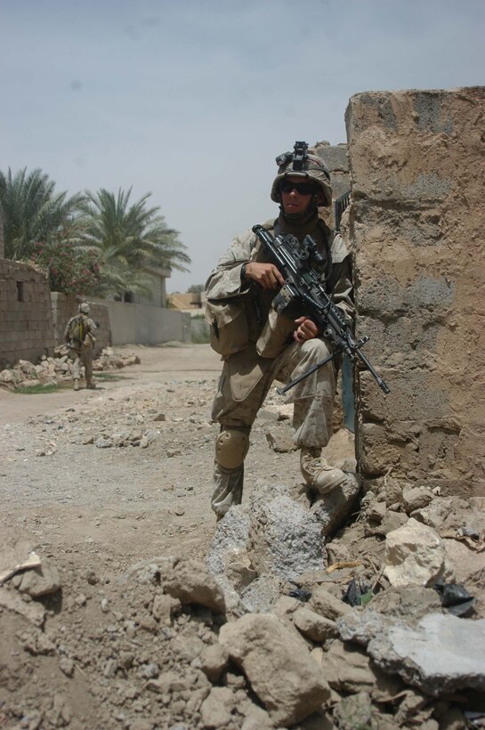 AR RAMADI, Iraq (May 13, 2005) -From a street corner here, Pfc. Dylan R. Mugan, a rifleman with 2nd Squad, 2nd Platoon, Company B, 1st Battalion, 5th Marine Regiment, posts security during a patrol. The 19-year old from Des Moines, Iowa, and his fellow 2nd Platoon warriors conducted a three-hour presence patrol, in over 90 degree temperatures, through a portion of their company's area of operations notorious for insurgent activity. The Marines encountered sporadic machine gun fire from insurgents during their mission, which was geared toward disrupting enemy activity. The Marines accomplished their mission and returned to their firm base, Camp Ramadi, safely. Photo By: Cpl. Tom Sloan