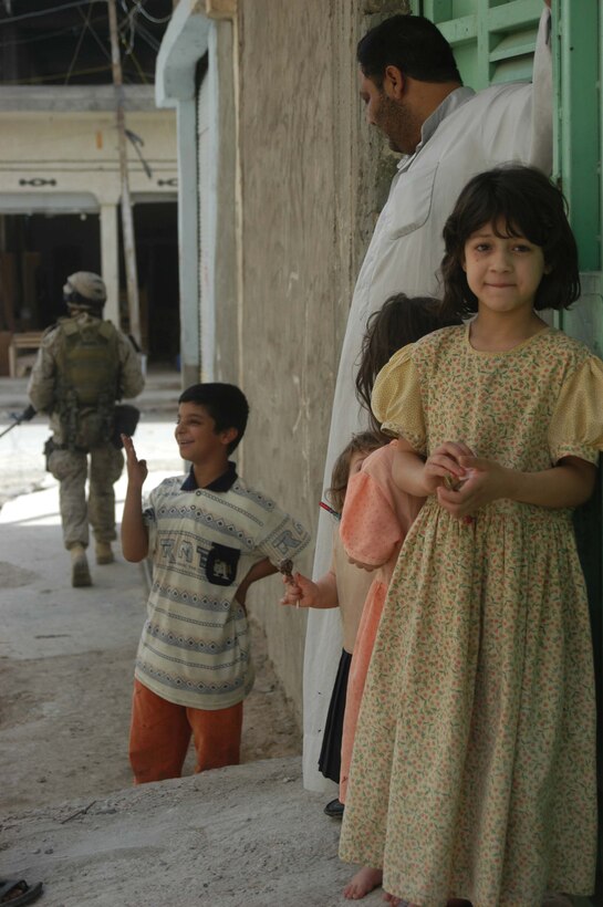 AR RAMADI, Iraq (May 13, 2005) - An Iraqi girl and her family greets Marines with 2nd Platoon, Company B, 1st Battalion, 5th Marine Regiment, as they patrol through their neighborhood here. Warriors with 2nd Platoon conducted a three-hour presence patrol through a portion of their company's area of operations notorious for insurgent activity. The Marines encountered sporadic machine gun fire from insurgents during their mission, which was geared toward disrupting enemy activity. The Marines accomplished their mission and returned to their firm base, Camp Ramadi, safely. Photo By: Cpl. Tom Sloan