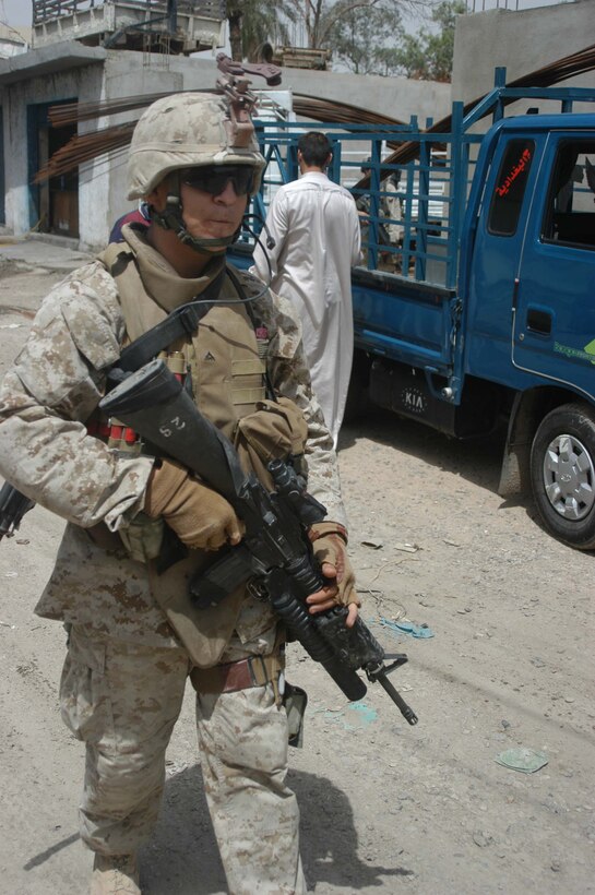 AR RAMADI, Iraq (May 13, 2005) - Lance Cpl. Aaron R. Martinez, a 21-year-old Lubbock, Texas, native and team leader with 2nd Squad, with 2nd Platoon, Company B, 1st Battalion, 5th Marine Regiment, walks down a busy street in the city here during a patrol. The 2001 Robertson High School graduate and his fellow 2nd Platoon warriors conducted a three-hour presence patrol through a portion of their company's area of operations notorious for insurgent activity. The Marines encountered sporadic machine gun fire from insurgents during their mission, which was geared toward disrupting enemy activity. The Marines accomplished their mission and returned to their firm base, Camp Ramadi, safely. Photo By: Cpl. Tom Sloan