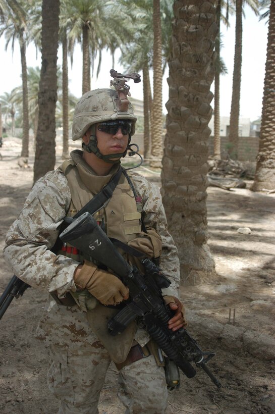 AR RAMADI, Iraq (May 13, 2005) - Lance Cpl. Aaron R. Martinez, a 21-year-old Lubbock, Texas, native and team leader with 2nd Squad, with 2nd Platoon, Company B, 1st Battalion, 5th Marine Regiment, conducts a patrol in city here beneath the shade of palm trees. The 2001 Robertson High School graduate and his fellow 2nd Platoon warriors conducted a three-hour presence patrol through a portion of their company's area of operations notorious for insurgent activity. The Marines encountered sporadic machine gun fire from insurgents during their mission, which was geared toward disrupting enemy activity. The Marines accomplished their mission and returned to their firm base, Camp Ramadi, safely. Photo By: Cpl. Tom Sloan