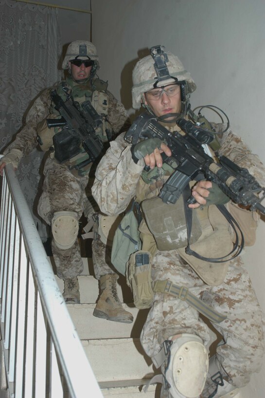 AR RAMADI Iraq (June 13, 2005) - Sergeant Tim R. Cyparski, a rifleman and the section leader for 1st Section, 1st Mobile Assault Platoon, Company W, 1st Battalion, 5th Marine Regiment, leads the way down a flight of stairs after searching the second floor of a house here with his comrade, Sgt. Michael A. Burgess, a 28-year-old assault man from Willoughby, Ohio. Insurgents attacked 27-year-old Cyparski from Erie, Pa., and his fellow warriors with an improvised explosive device during a presence patrol they executed in the southern portion of the city. No one was hurt and no vehicles were damaged. Photo by: Cpl. Tom Sloan