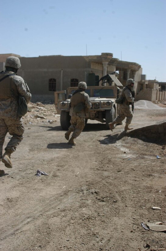 AR RAMADI Iraq (June 14, 2005) - Three Marines with 1st Section, 1st Mobile Assault Platoon, Company W, 1st Battalion, 5th Marine Regiment, quickly move through a street here during a mission. Insurgents attacked the Marines with an improvised explosive device during a presence patrol they executed in the southern portion of the city. No one was hurt and no vehicles were damaged. Photo by: Cpl. Tom Sloan