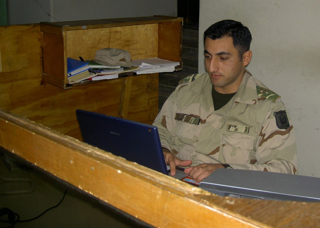 Hadithah Dam, Hadithah, Iraq.-- 1st Lt. Rashad Garayev works at the duty desk on the Azerbaijani side of the dam.  The Azerbaijanis are responsible for maintaining accurate records of work permits and identification cards issued to Iraqi dam workers.  Hundreds of ID cards are inspected each week to ensure they are not forged.  (Photo by Azerbaijan Army Pvt. Mirzebeyov)