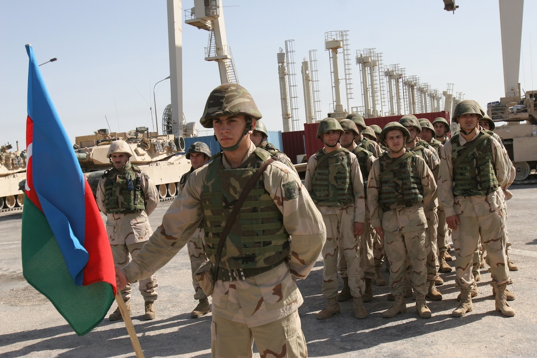 Hadithah Dam, Hadithah, Iraq.-- A formation of Azerbaijani soldiers stands at parade rest during a memorial ceremony for the Marines killed in Operation Matador.  The Azerbaijanis attended every Marine memorial service.  They follow the Marines through the line at the end of the service to pay their respects to their fallen allies.  (Photo by Lance Cpl. Marc Fencil)