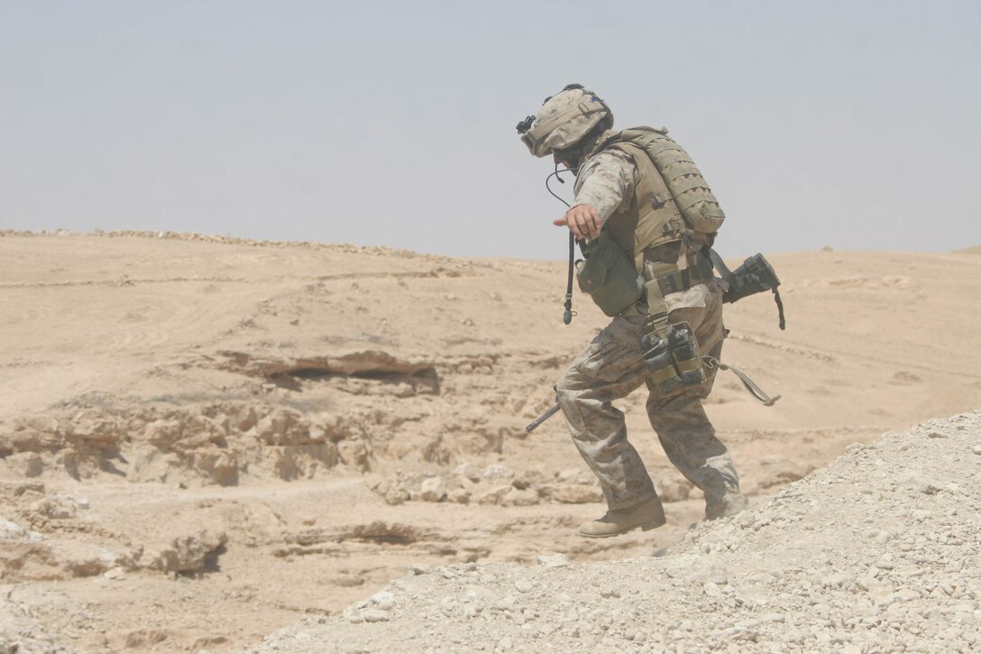 BANI DAHRI, Iraq - Lance Cpl. Matt Greene, a Winston-Salem, N.C., native and team leader with 1st Squad, 3rd Platoon, K Company, 3rd Battalion, 2nd Marine Regiment, Regimental Combat Team 2 slides down into a wadi to search it during Operation Quick Strike.