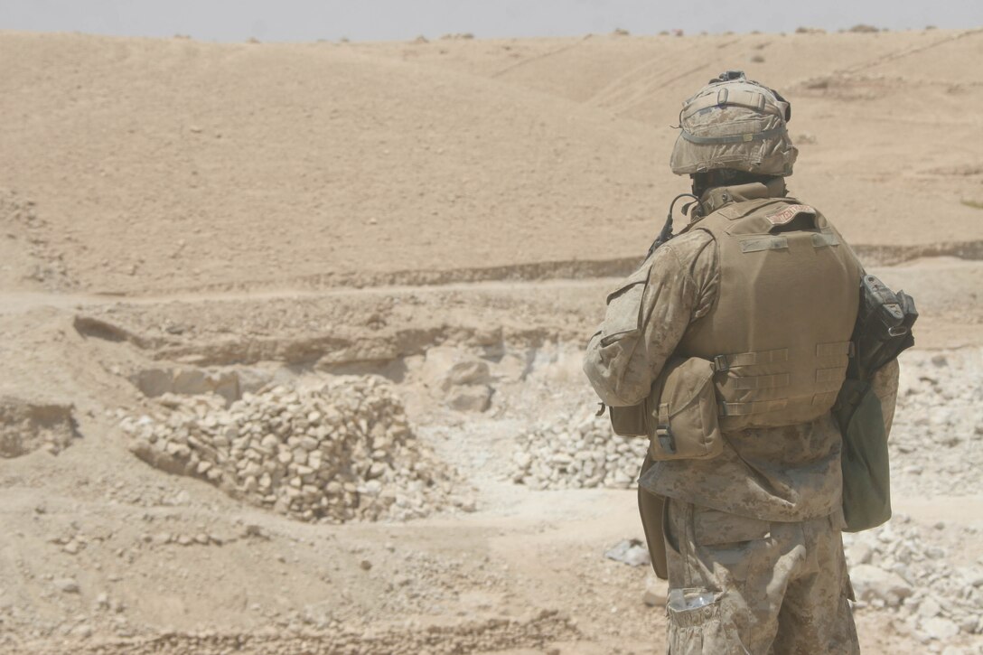 BANI DAHRI, Iraq - Sgt. Jeffrey J. Swartzentruber, a Coral Springs, Fla., native and the squad leader of 1st Squad, 3rd Platoon, K Company, 3rd Battalion, 2nd Marine Regiment, Regimental Combat Team 2, scans a wadi during Operation Quick Strike.