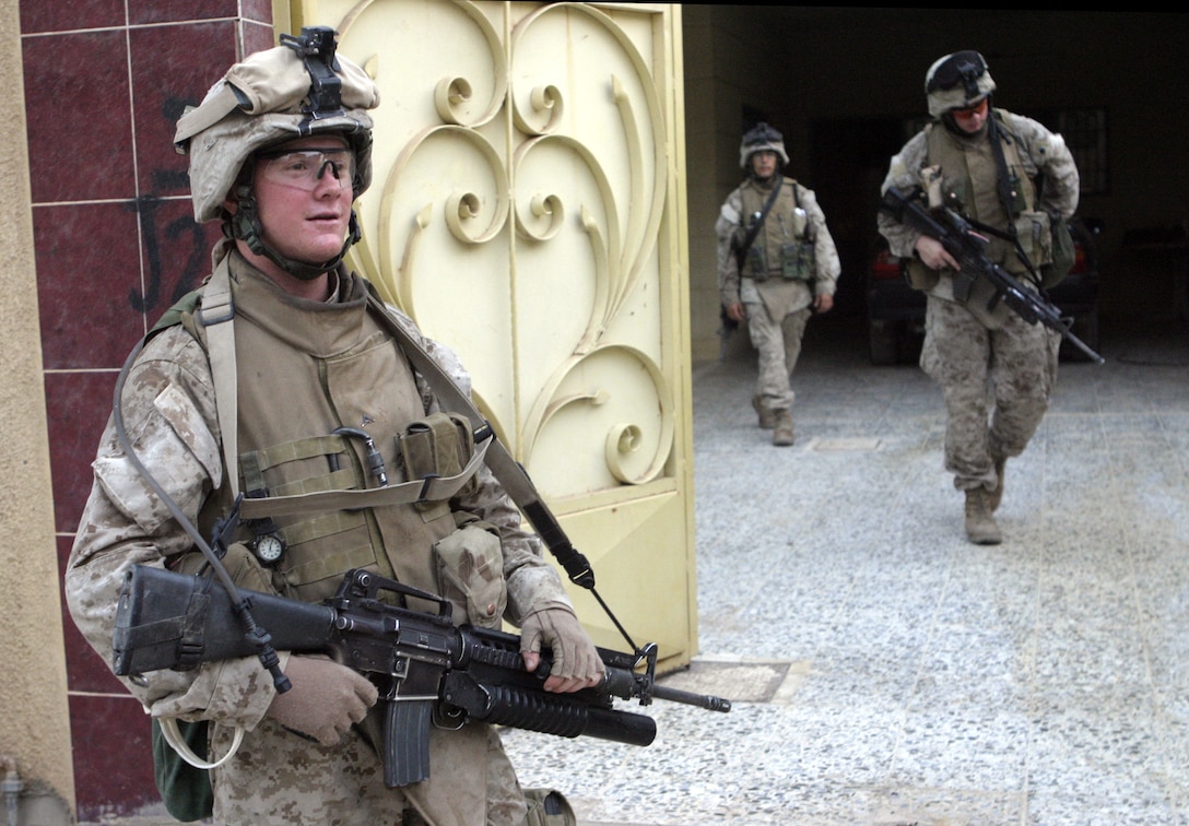 FALLUJAH, Iraq - Lance Cpl. Slade Clark, an infantryman with 1st Platoon, Company C, 1st Battalion, 6th Marine Regiment, provides security outside a home here Aug. 13 during Operation Hard Knock.   The battalion's Marines and Iraqi Security Forces blocked off a sector of Northwestern Fallujah to search dozens of houses for weapons and to gather census information on the populace.
