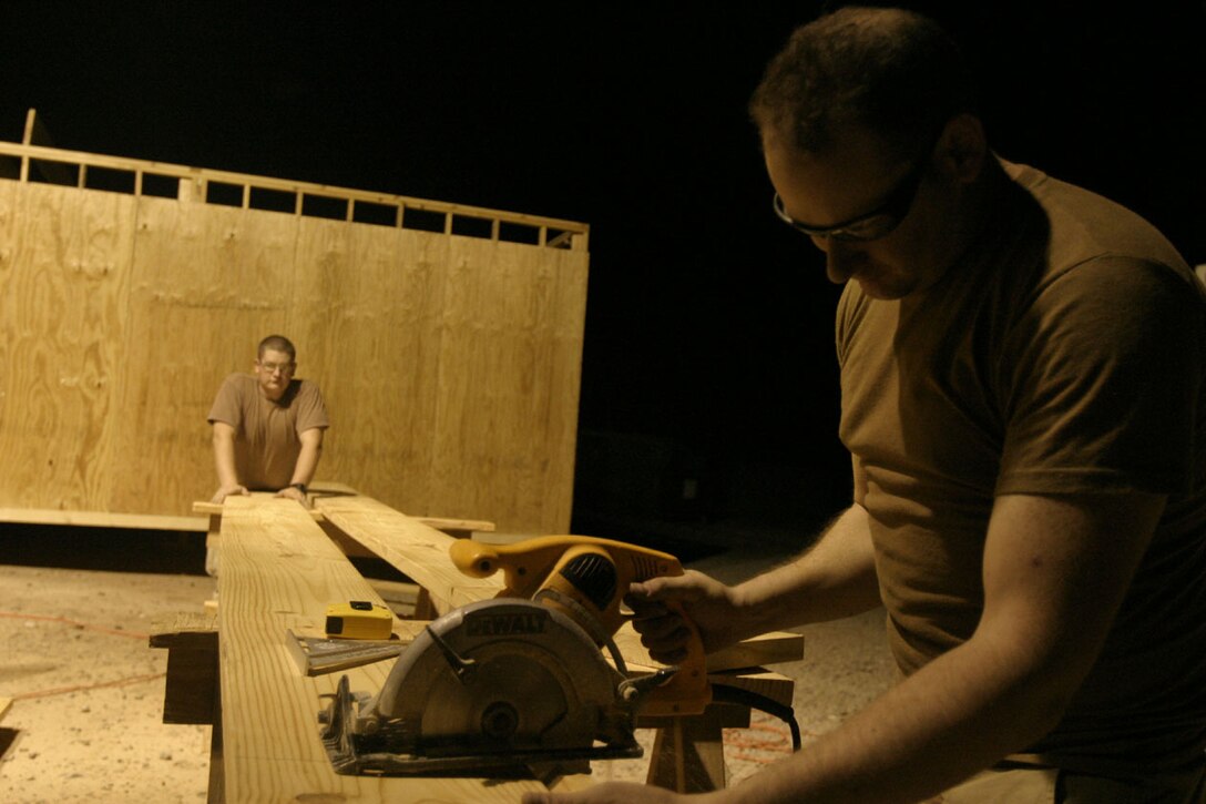 CAMP RIPPER, AL ASAD, Iraq (August 13, 2005)- Spc. Aaron N. Leva, 26, from Houston and an engineer with Company A, 463rd Engineer Battalion cuts wood to be placed on the new camp chapel. The chapel is being built to allow more people from outside the camp and overall more people attend church services. The construction is expected to be complete by next month. (Official U.S. Marine Corps photo by Lance Cpl. Lucian Friel (RELEASED)