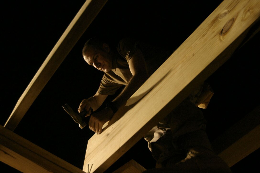 CAMP RIPPER, AL ASAD, Iraq (August 13, 2005)- Army Staff Sgt. Marc A. Lange, 27, from Spokane, Wash., and an engineer with Company A, 463rd Engineer Battalion hammers on the new camp chapel. The chapel is being built to allow more people from outside the camp and overall more people attend church services. The construction is expected to be complete by next month. (Official U.S. Marine Corps photo by Lance Cpl. Lucian Friel (RELEASED)
