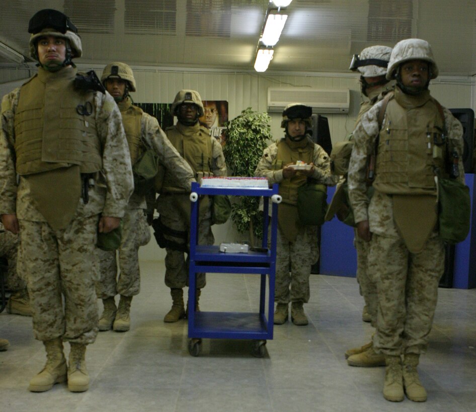 CAMP BLUE DIAMOND, AR RAMADI, Iraq - Escorts flank the traditional birthday cake during a ceremony for the 230th birthday of the Navy. Service members with the 2nd Marine Division celebrated the Navy's birthday with a traditional cake cutting ceremony.