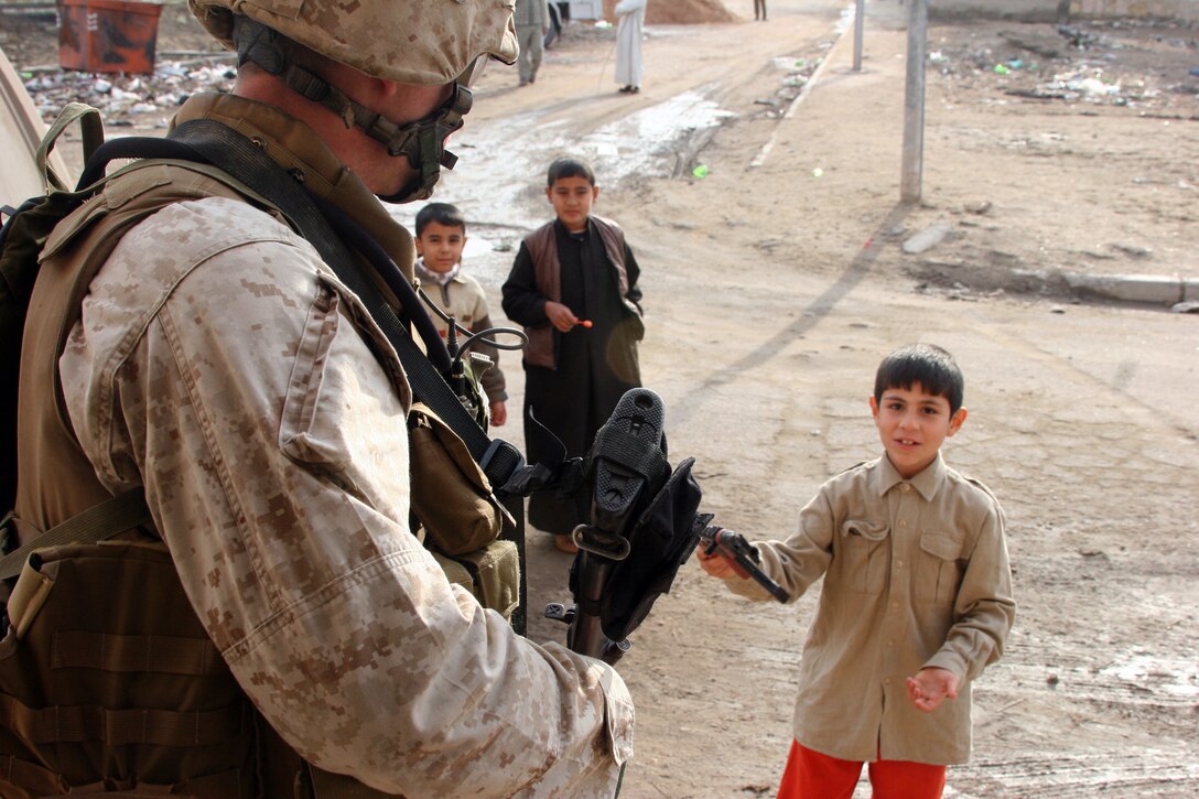 AR RAMADI, IRAQ (January 13, 2006) – A Marine with Company I, 3rd Battalion, 7th Marine Regiment, interacts with some Iraqi children during a patrol with a local Iraqi Army unit Jan. 13. The patrol was part of the training that the Marines are conducting with the IA to prepare them for providing security for their country. Photo by Cpl. Shane Suzuki