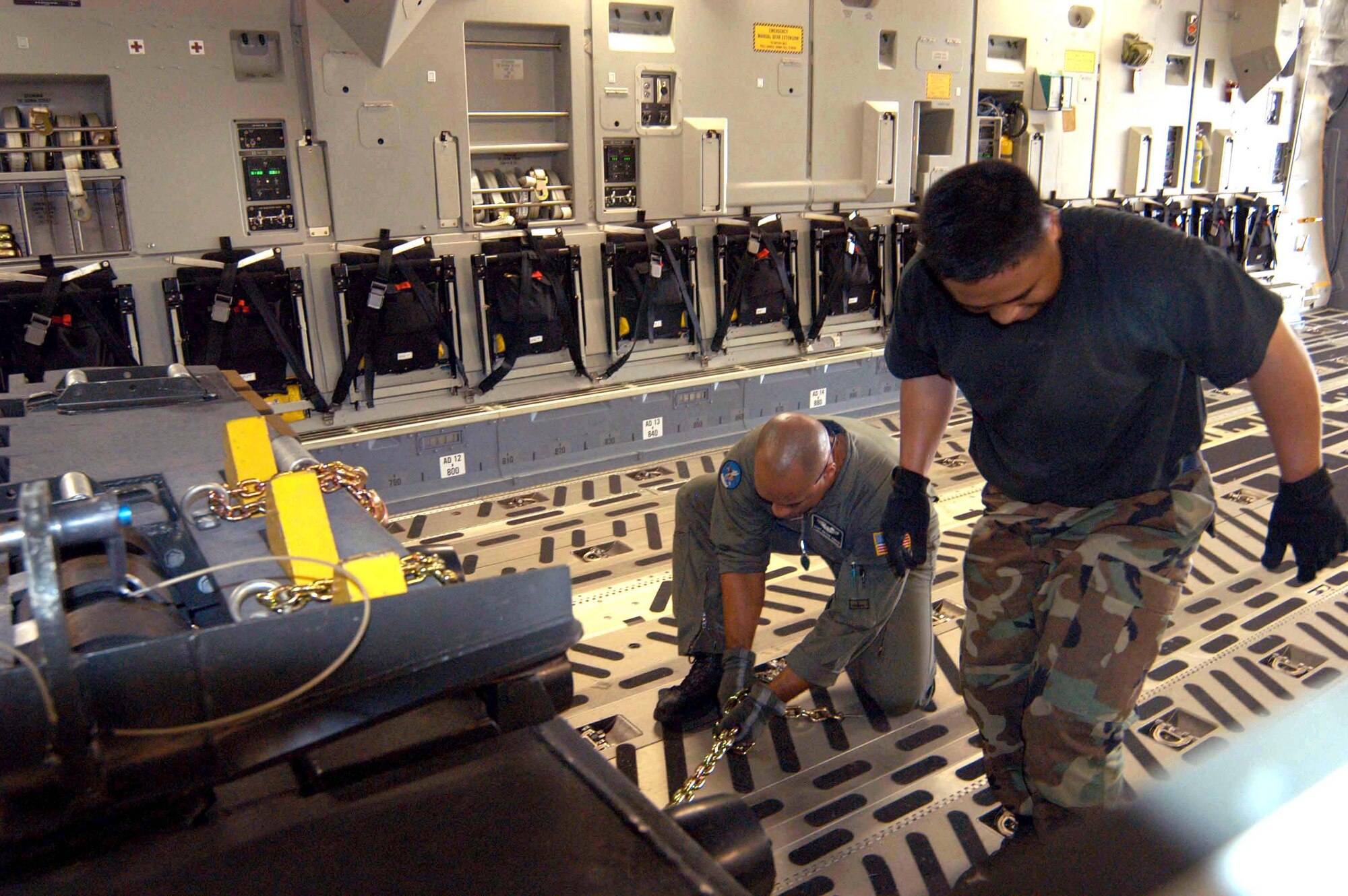 UTAPAO, Thailand -- Staff Sgt. Bryan Amaya (left) and Master Sgt. Darwin Basaca work to secure equipment onboard a C-17 Globemaster III bound for Banda Aceh, Indonesia.  Sergeant Amaya is a loadmaster with the 8th Airlift Squadron at McChord Air Force Base, Wash., and Sergeant Basaca is with the 615th Air Mobility Squadron from Travis Air Force Base, Calif.  (U.S. Air Force photo by Samantha L. Quigley)