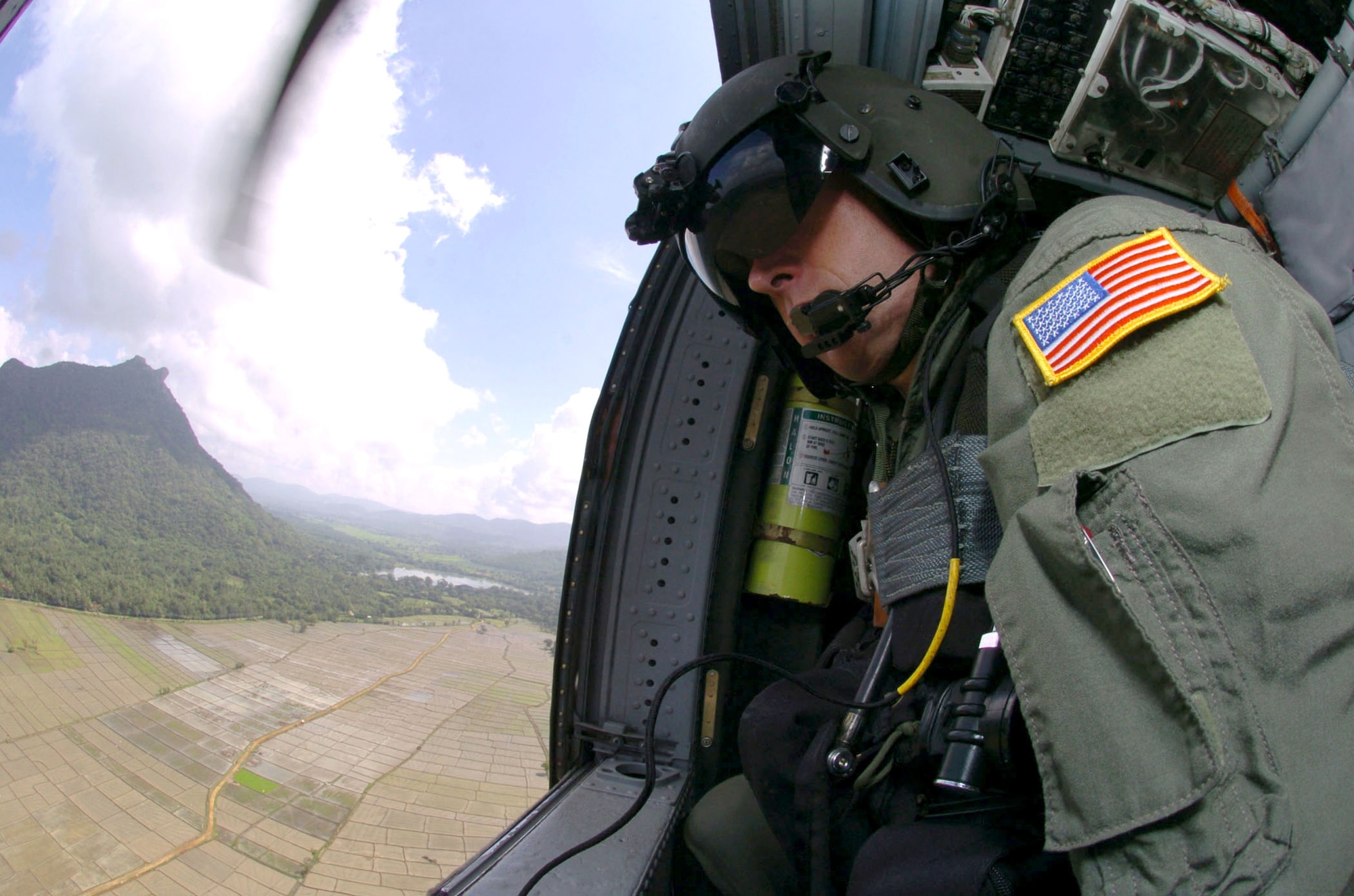 OVER SRI LANKA -- Tech. Sgt. Keith Kolb scans the countryside below as he flies aboard an HH-60G Pave Hawk helicopter during an Operation Unified Assistance mission here.  The Kadena Airmen are helping bring food, medicines and supplies to people affected by the Dec. 26 tsunamis.  Sergeant Kolb is an aerial gunner from the 33rd Rescue Squadron at Kadena Air Base, Japan.  (U.S. Air Force photo by Master Sgt. Val Gempis)