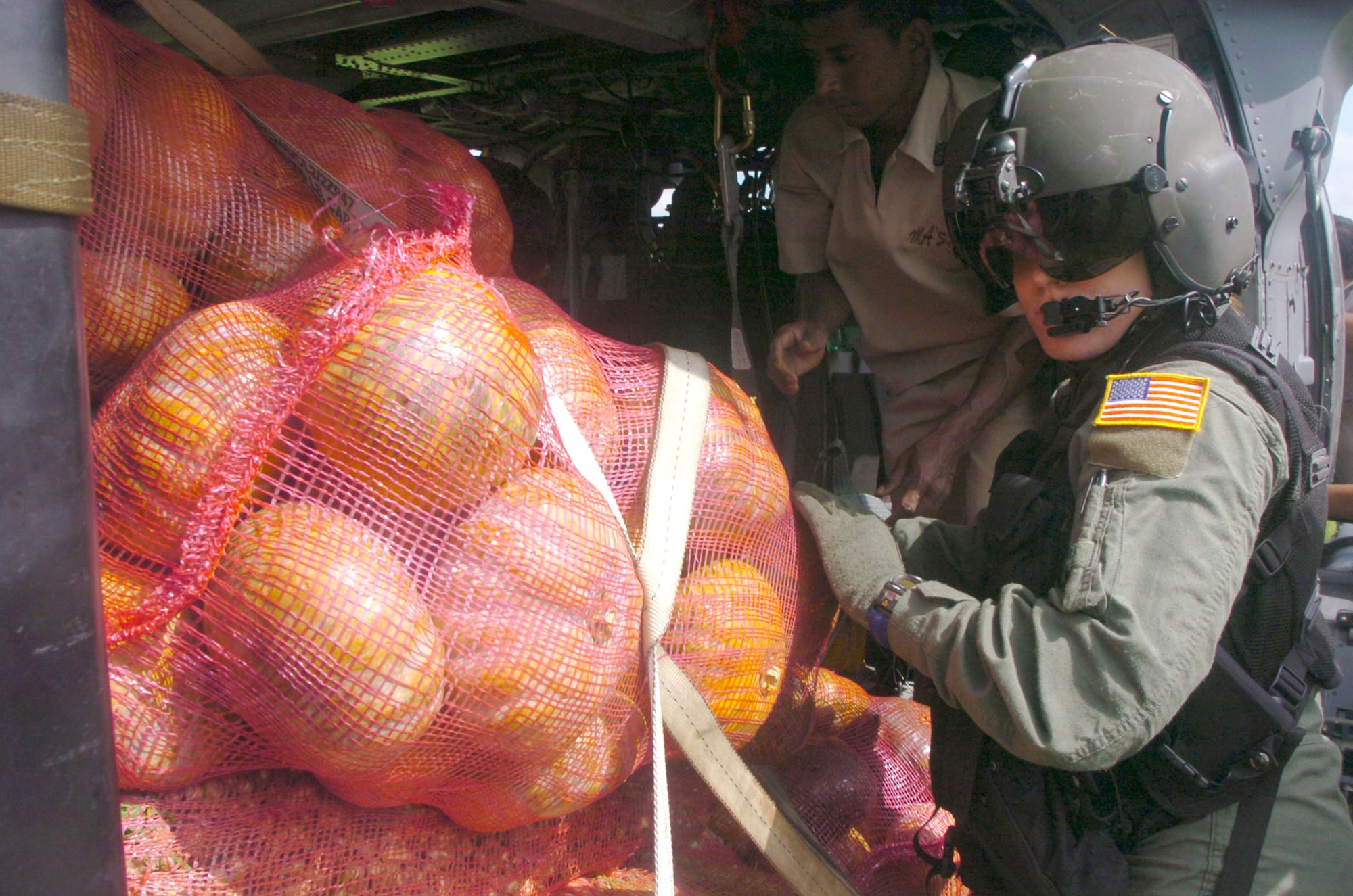 DAMBULA, Sri Lanka -- Airman 1st Class Emily Starcher helps Sri Lankan relief workers unload boxes of vegetables from an HH-60G Pave Hawk helicopter during an Operation Unified Assistance mission here Jan. 12.  She is a flight engineer assigned to the 33rd Rescue Squadron at Kadena Air Base, Japan.  The Kadena Airmen are helping bring food, medicines and supplies to people affected by the Dec. 26 tsunamis.  (U.S. Air Force photo by Master Sgt. Val Gempis)