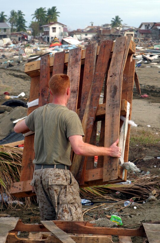 Cpl. Phillip J. Camp of the 15th Marine Expeditionary Unit (Special Operations Capable) helps clear the beach for a Landing Craft Air Cushioned filled with humanitarian aid supplies to land.