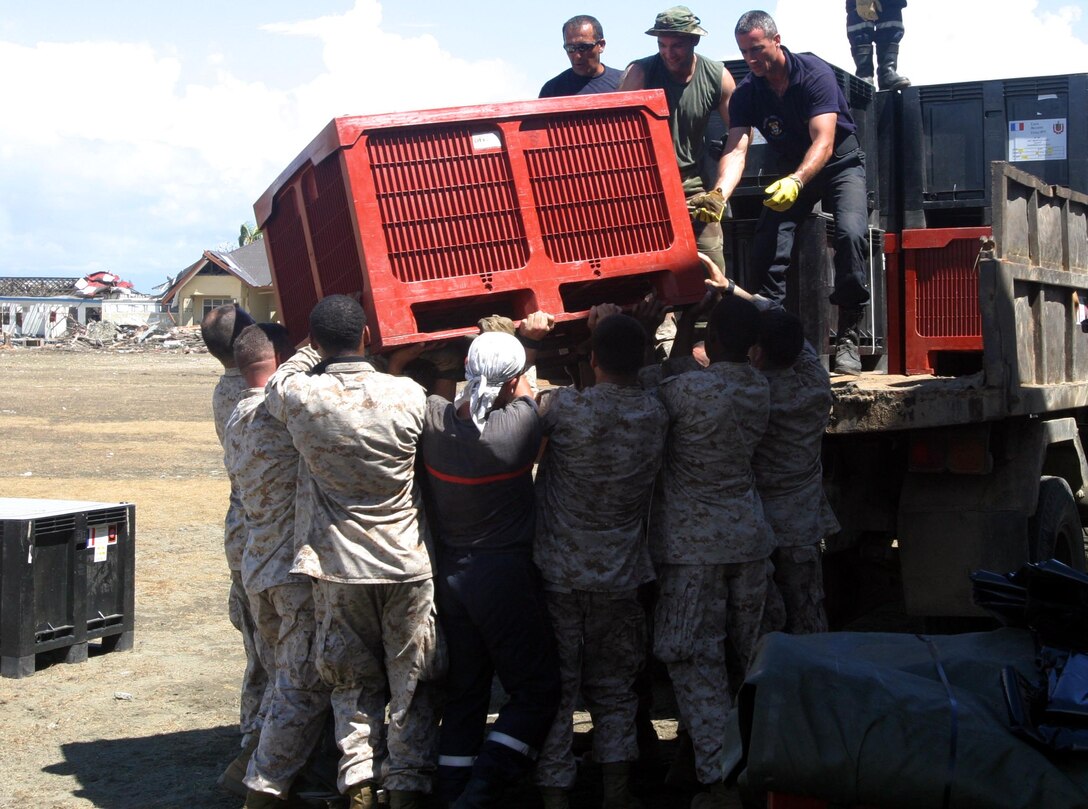 Marines and sailors with the 15th Marine Expeditionary Unit (Special Operations Capable) teamed up with French service members while loading humanitarian aid supplies into the back of a utility vehicle that were to be distributed to victims of the recent tsunami.